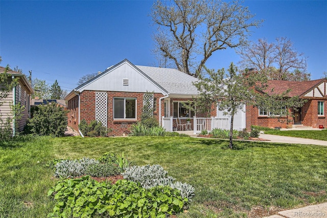 5703 Ammons St, Arvada, CO 80002 - tudor house featuring brick siding, a front yard, a chimney, and a shingled roof