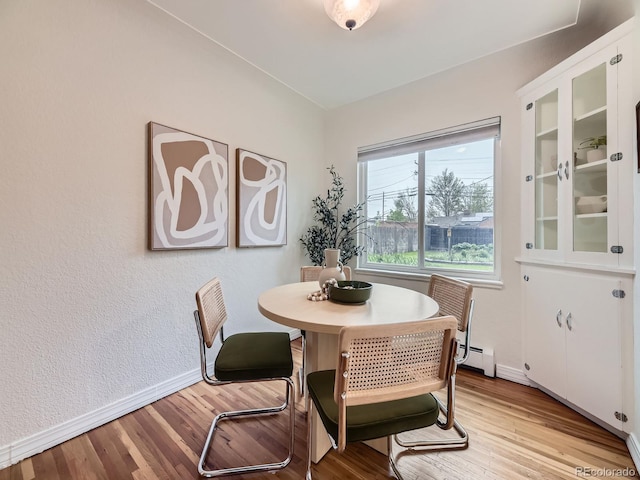 5703 Ammons St, Arvada, CO 80002 - dining space with baseboard heating, light wood-style flooring, and baseboards