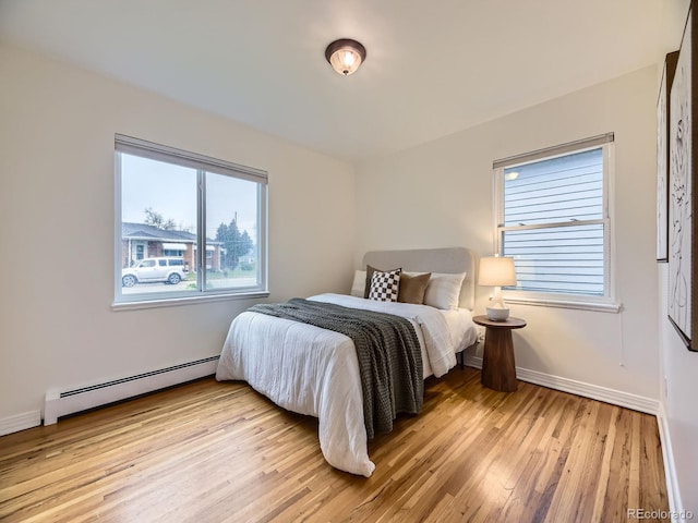 5703 Ammons St, Arvada, CO 80002 - bedroom featuring a baseboard radiator, light wood-style flooring, and baseboards