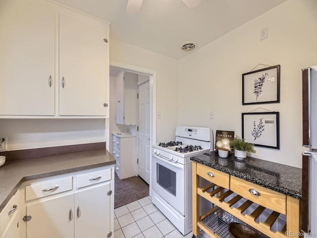 5703 Ammons St, Arvada, CO 80002 - kitchen with white range with gas stovetop, white cabinets, and dark countertops