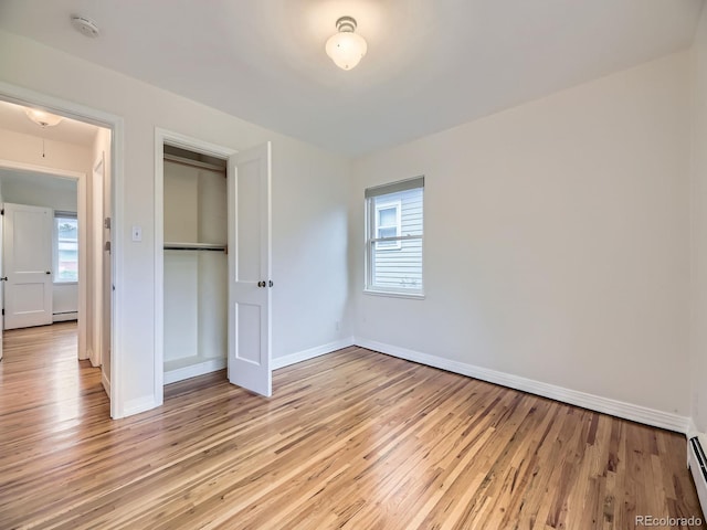 5703 Ammons St, Arvada, CO 80002 - unfurnished bedroom featuring multiple windows, light wood-type flooring, and baseboards