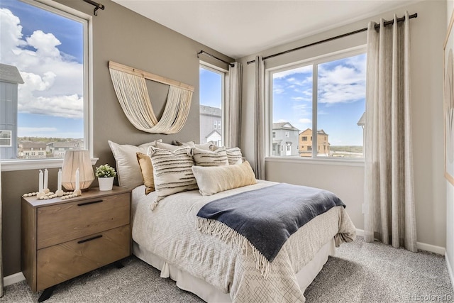 bedroom featuring light carpet and multiple windows