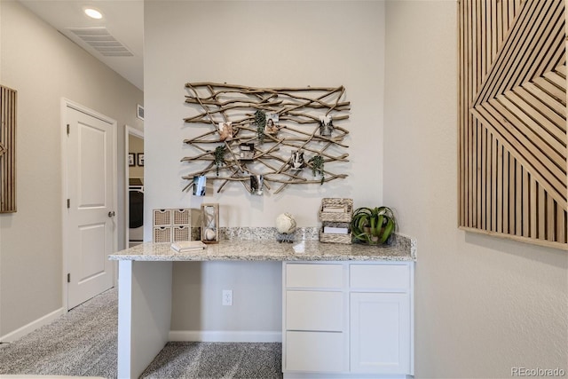 bar with white cabinetry, oven, light stone countertops, and dark colored carpet