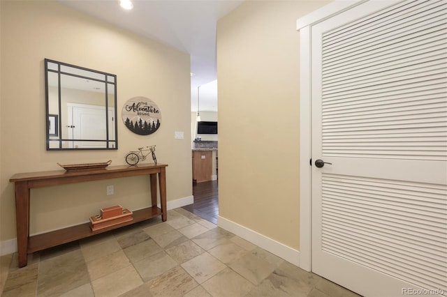 hall with recessed lighting and baseboards