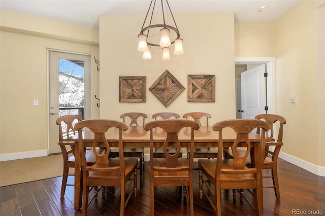 dining space with a notable chandelier, dark wood finished floors, and baseboards