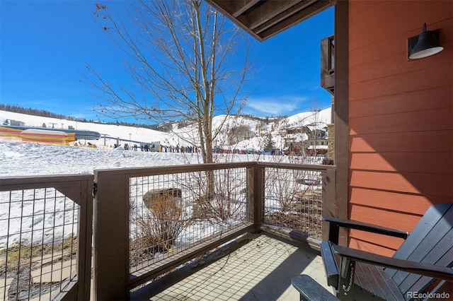 snow covered back of property with a mountain view