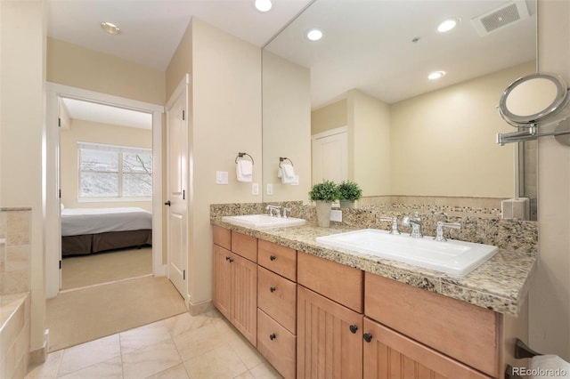 ensuite bathroom with recessed lighting, visible vents, a sink, and double vanity