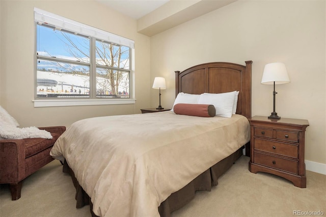 bedroom featuring light colored carpet and baseboards