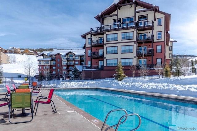 snow covered pool with fence and a community pool