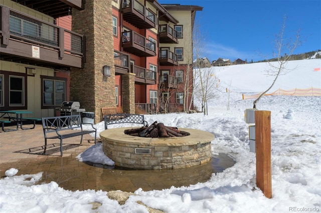 view of community featuring a patio area and an outdoor fire pit