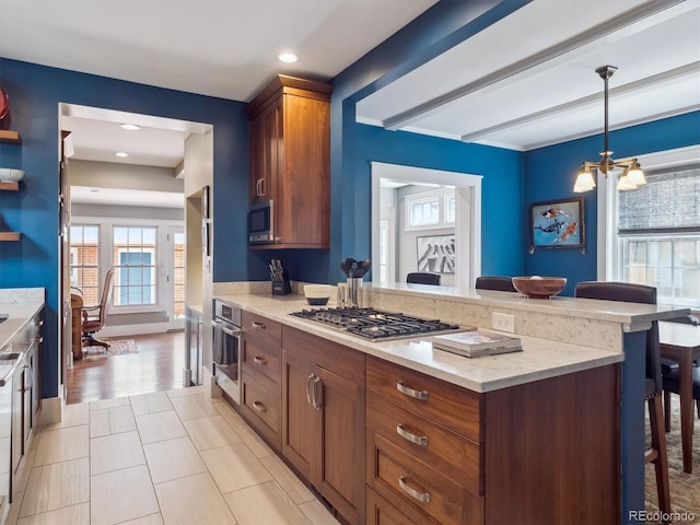 724 N Franklin St, Denver, CO 80218 - kitchen with appliances with stainless steel finishes, a peninsula, a breakfast bar area, a chandelier, and light stone counters