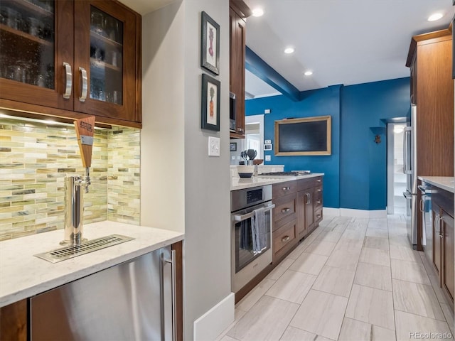724 N Franklin St, Denver, CO 80218 - kitchen featuring stainless steel appliances, backsplash, glass insert cabinets, recessed lighting, and light stone countertops