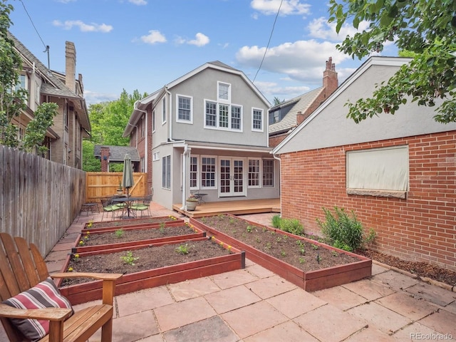 724 N Franklin St, Denver, CO 80218 - back of property with a garden, a patio, stucco siding, and brick siding