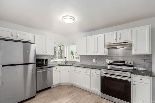 kitchen featuring dark stone countertops, appliances with stainless steel finishes, sink, and white cabinets