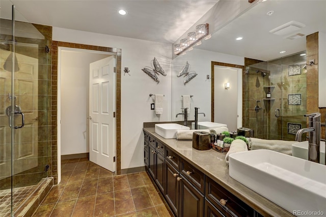 full bathroom featuring double vanity, a shower stall, and a sink