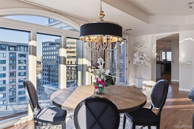 dining room with hardwood / wood-style flooring and an inviting chandelier