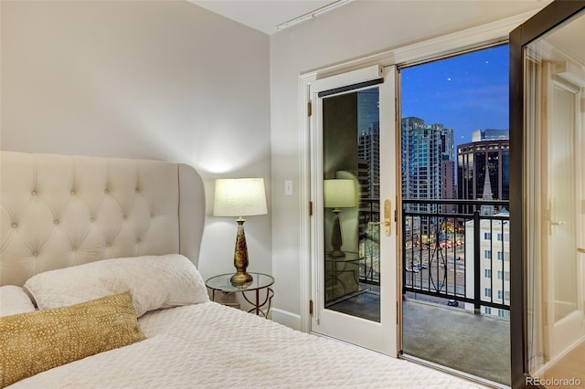 bedroom featuring access to exterior and a city view