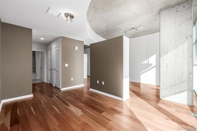 spare room with visible vents, baseboards, and wood finished floors