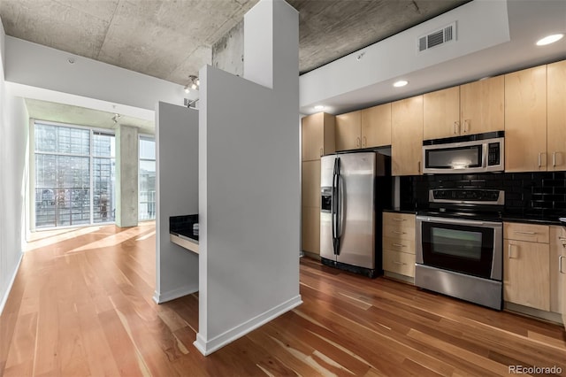 kitchen featuring visible vents, appliances with stainless steel finishes, wood finished floors, and light brown cabinetry