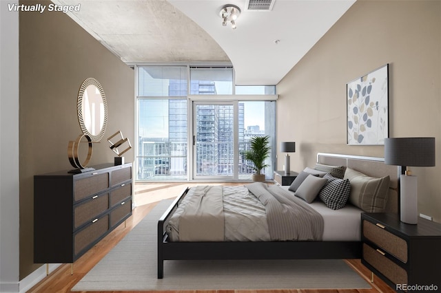 bedroom featuring light hardwood / wood-style flooring and floor to ceiling windows