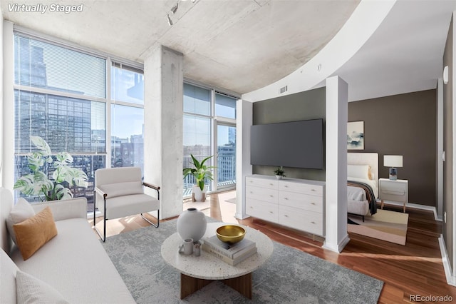 living room with visible vents, a wall of windows, and wood finished floors