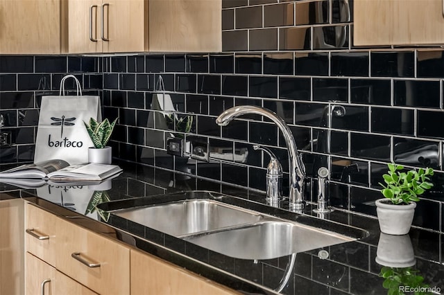 kitchen featuring dark countertops, light brown cabinets, a sink, and backsplash