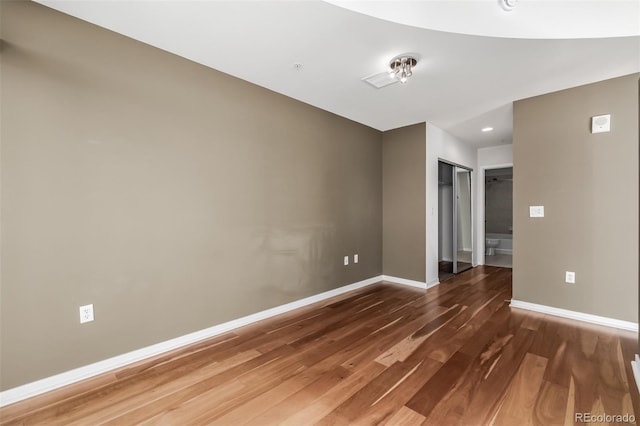 empty room featuring wood finished floors and baseboards