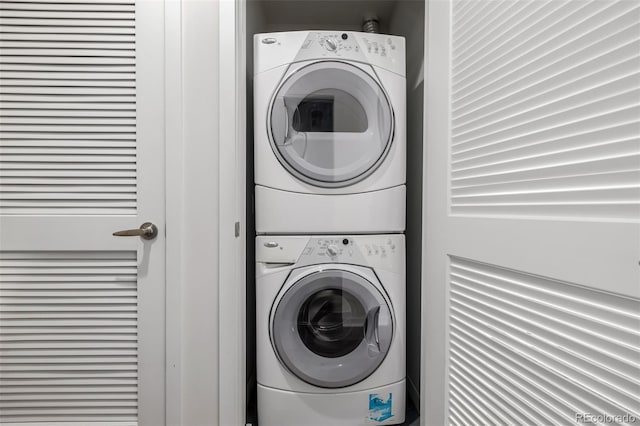 clothes washing area with stacked washer and dryer and laundry area