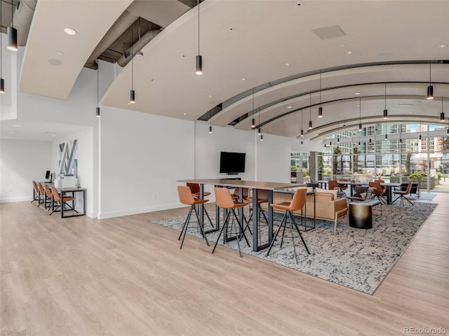 dining room featuring vaulted ceiling, baseboards, and wood finished floors