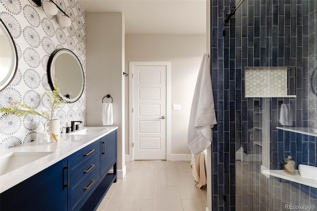 full bathroom with tiled shower, a sink, baseboards, and double vanity