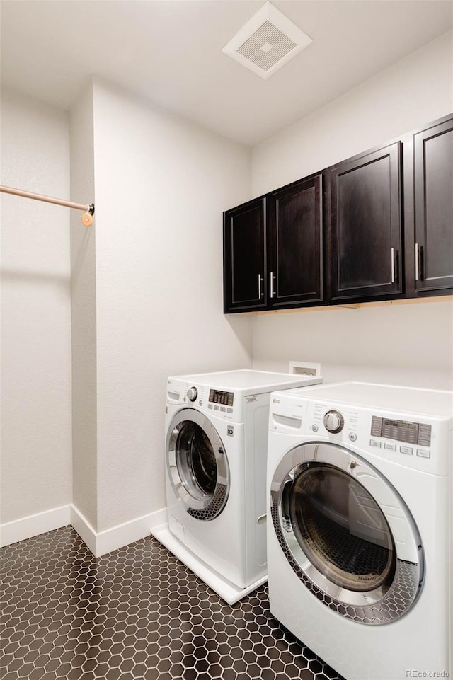 clothes washing area with independent washer and dryer, visible vents, cabinet space, and baseboards