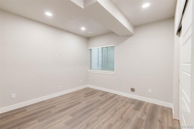 spare room with light wood-type flooring, visible vents, baseboards, and recessed lighting