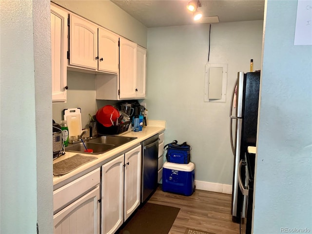 kitchen featuring white cabinets, sink, light hardwood / wood-style floors, appliances with stainless steel finishes, and electric panel