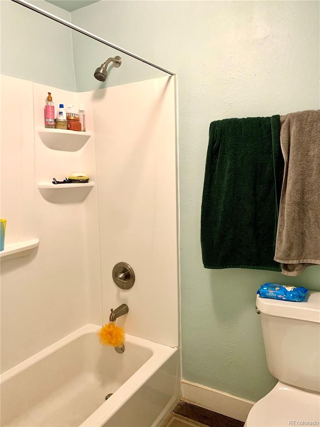 bathroom featuring shower / washtub combination and toilet