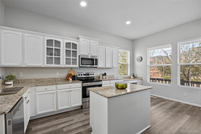 kitchen with stainless steel appliances, recessed lighting, white cabinets, and wood finished floors