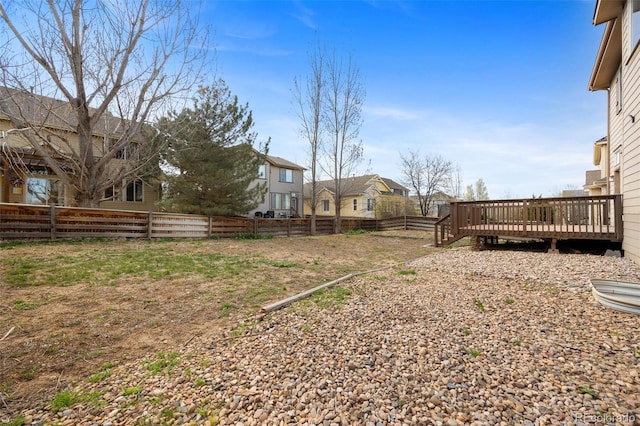 view of yard with a residential view, a deck, and a fenced backyard