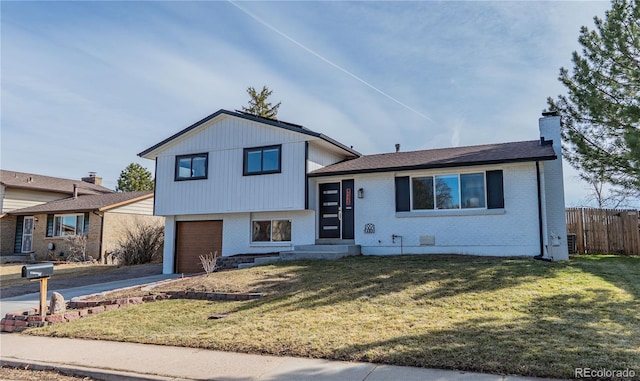 tri-level home with a front lawn, fence, brick siding, and a chimney