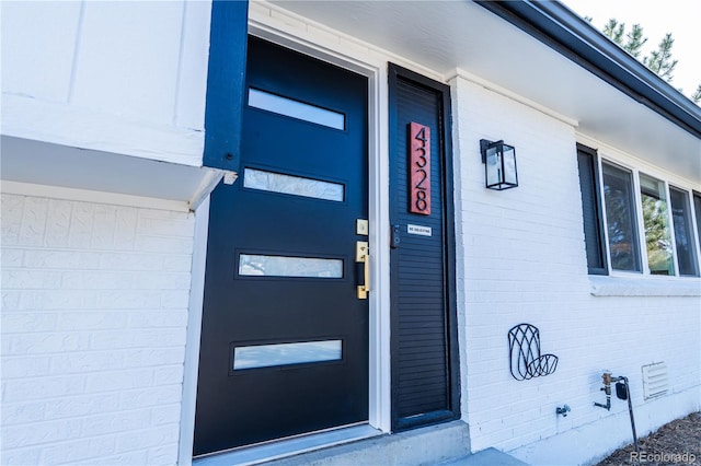 property entrance with crawl space and brick siding