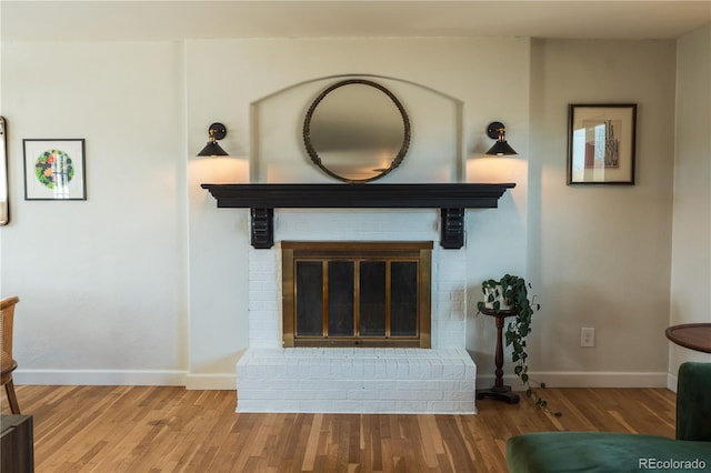 room details featuring baseboards, wood finished floors, and a fireplace