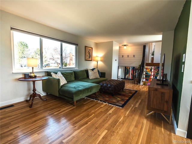 living room with baseboards, visible vents, and wood-type flooring