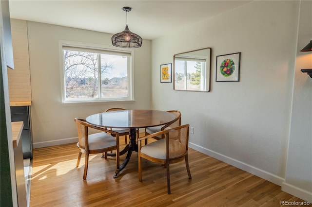 dining space with plenty of natural light, light wood-style flooring, and baseboards