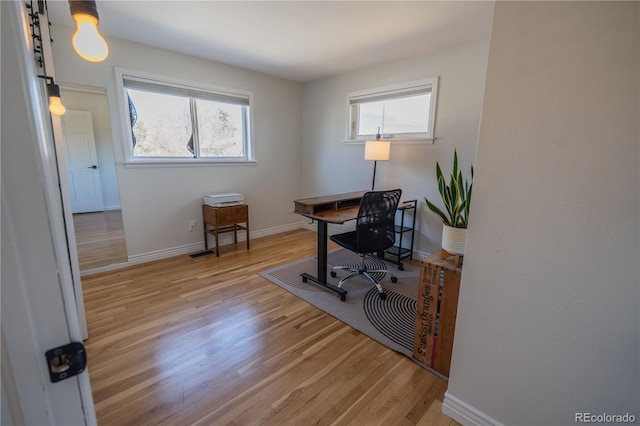 office space with light wood-style flooring and baseboards