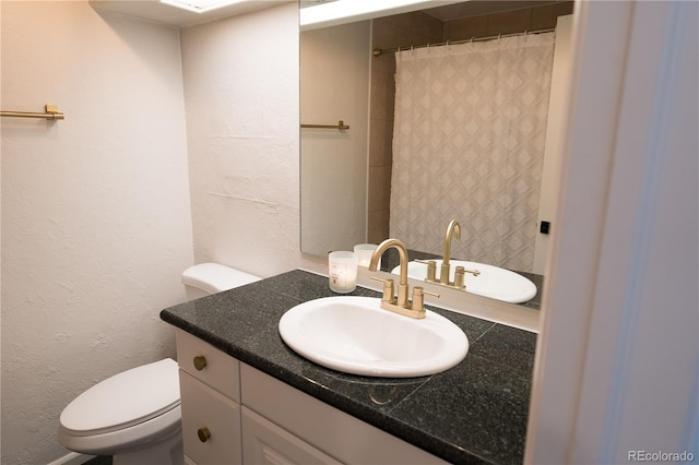 full bath featuring a shower with shower curtain, toilet, vanity, and a textured wall