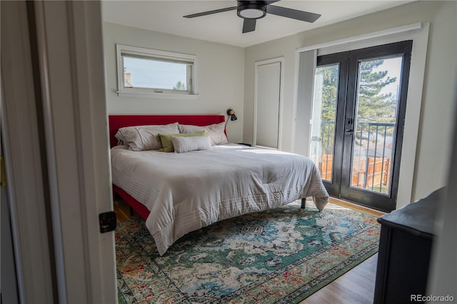 bedroom featuring multiple windows, french doors, wood finished floors, and access to outside