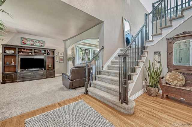 1410 Old Sequoia Ct, Franktown, CO 80116 - stairs with arched walkways, wood finished floors, and baseboards