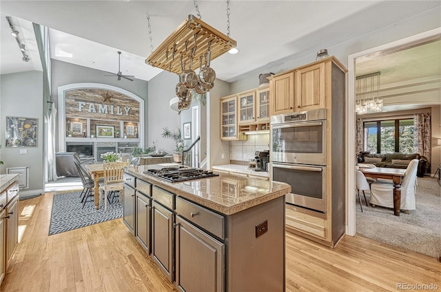 1410 Old Sequoia Ct, Franktown, CO 80116 - kitchen featuring appliances with stainless steel finishes, a chandelier, a kitchen island, light wood-type flooring, and lofted ceiling