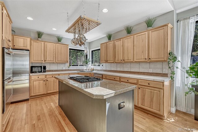1410 Old Sequoia Ct, Franktown, CO 80116 - kitchen with light brown cabinetry, black appliances, healthy amount of natural light, and recessed lighting