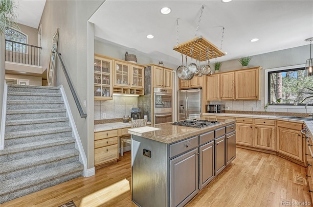 1410 Old Sequoia Ct, Franktown, CO 80116 - kitchen with stainless steel appliances, light wood finished floors, decorative backsplash, light brown cabinets, and recessed lighting