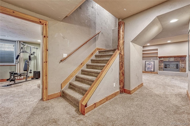 1410 Old Sequoia Ct, Franktown, CO 80116 - staircase with carpet flooring, a textured wall, baseboards, a tiled fireplace, and recessed lighting