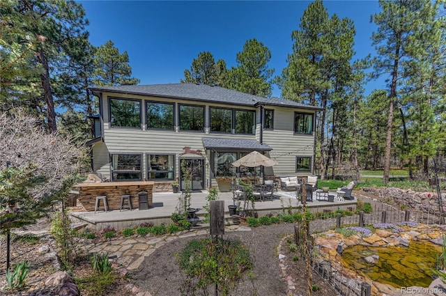 1410 Old Sequoia Ct, Franktown, CO 80116 - rear view of property featuring a patio area, stone siding, and roof with shingles